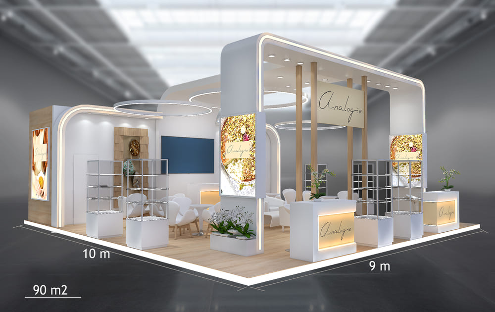 Stand de 90 m² (9 × 10 m): isla abierta por cuatro lados, zona lounge y área de demostración.